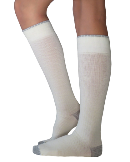 A pair of natural and grey colour merino wool knee-high compression socks worn on a model&