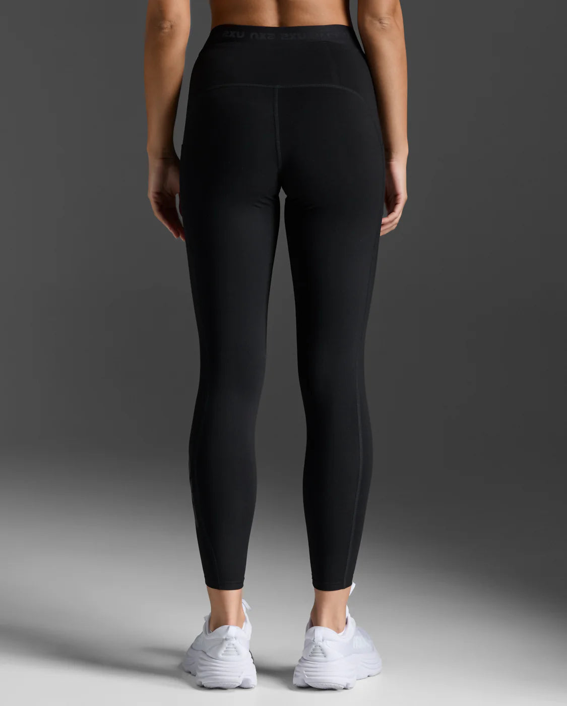 Back view of 2XU Form Stash Hi-Rise Compression Tights in black showing the high-rise waistband and flattering fit.