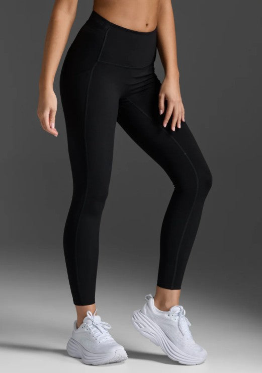 Woman wearing 2XU Form Stash Hi-Rise Compression Tights in black with phone pocket